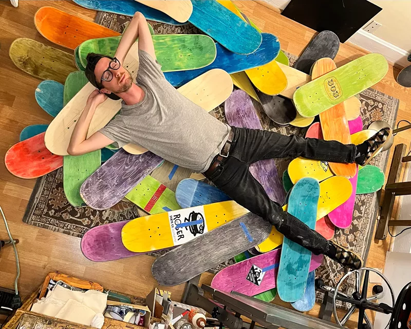 Image: a man lying on top of skateboard decks