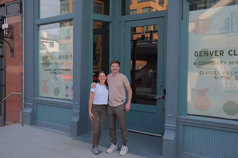Image: two people stand in front of a building