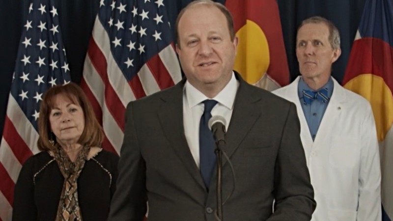 Governor Jared Polis, flanked by Dianne Primavera and Dr. Eric France, during a February 25 press conference about COVID-19.