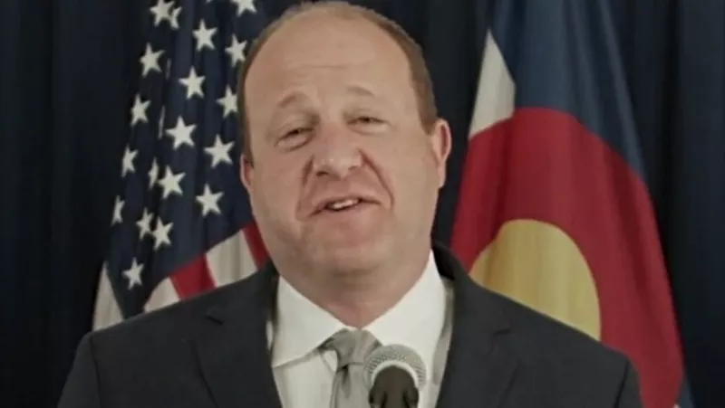 Image: Governor Jared Polis unmasked at a May 14 press conference.