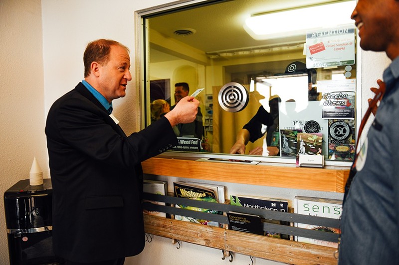 Jared Polis gets his ID checked before entering bgood dispensary for a business tour on April 20, 2018.