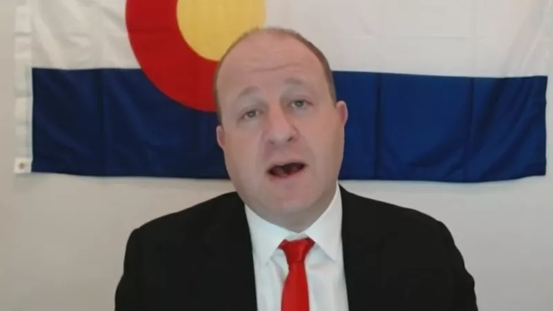 Image: Governor Jared Polis taking part in a remote press conference on October 6.