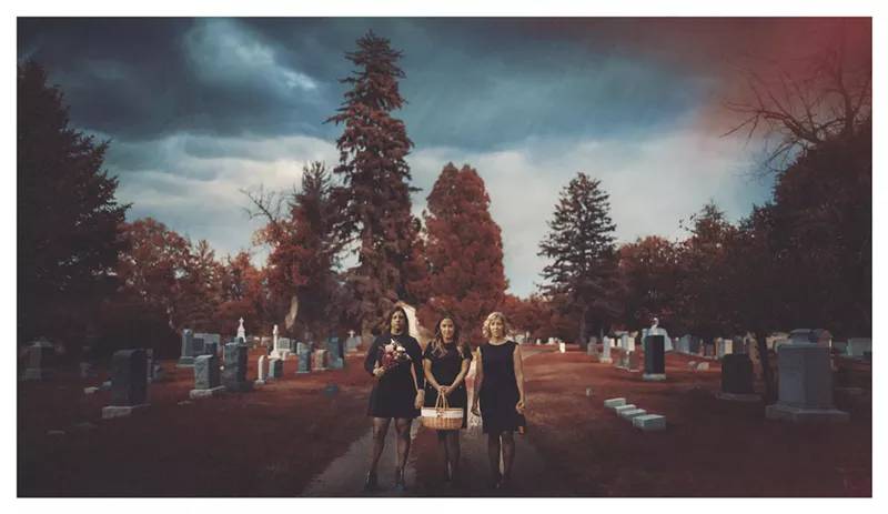 Image: Three women walk together outside.