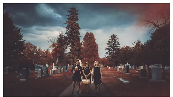 Three women walk together outside.