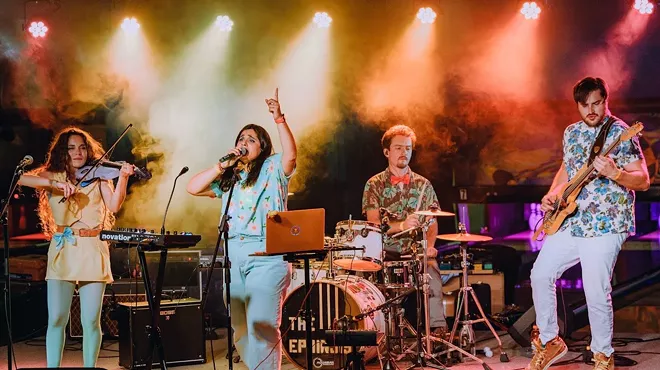 a band performing on stage with pretty lights