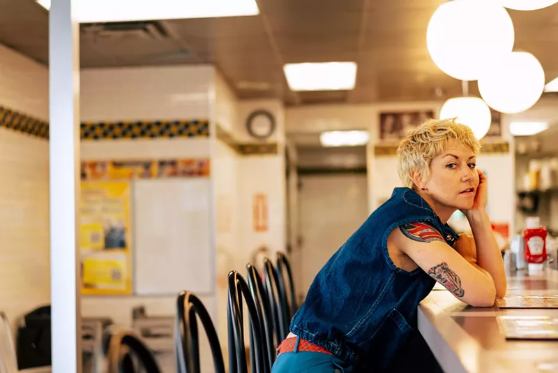 Image: woman with pixie cut leans on diner bar