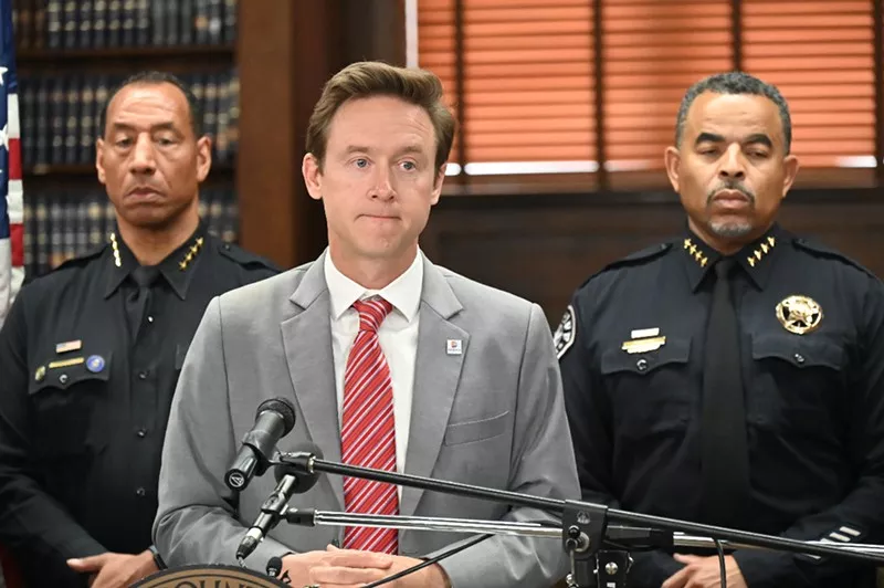 Image: man in suit by police officers