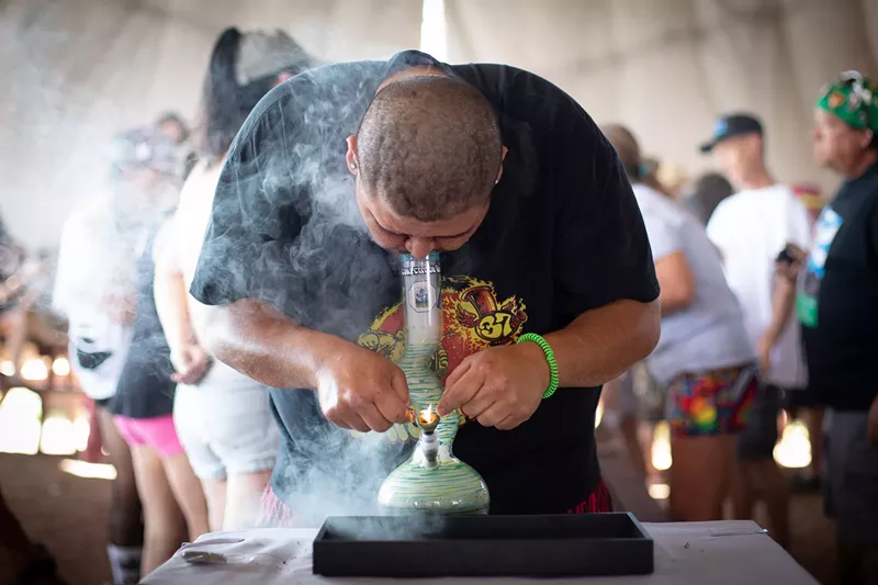 Image: A man hits weed from a bong