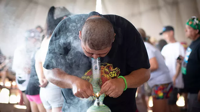 A man hits weed from a bong