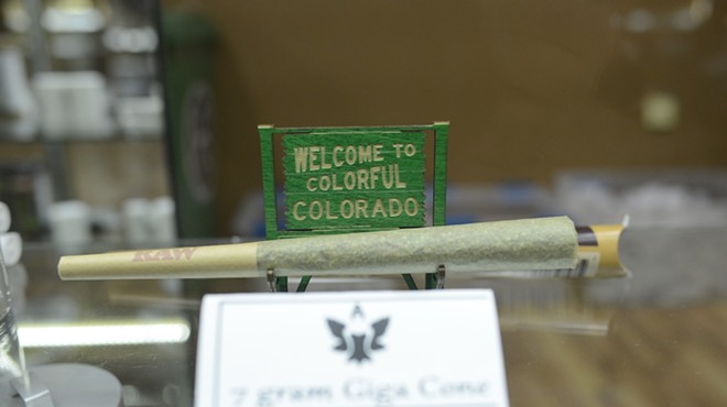 A marijuana joint in front of a Colorful Colorado sign