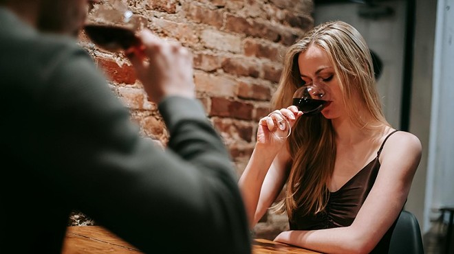 woman at table with man drinking red wine