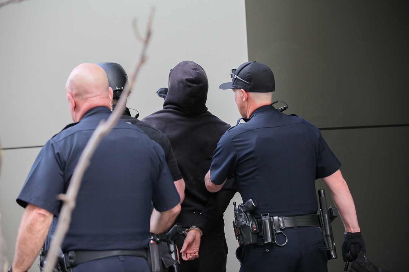 Denver police arrest a protester outside the Grand Hyatt on March 18; a Turning Point USA regional conference was being held inside the hotel.