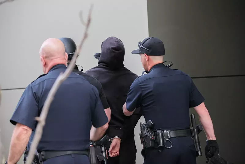 Image: Denver police arrest a protester outside the Grand Hyatt on March 18; a Turning Point USA regional conference was being held inside the hotel.