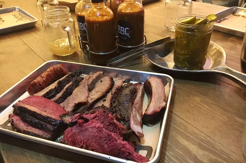 Image: Brisket, ribs, sausage and pastrami, with housemade sauces and pickles at AJ's.