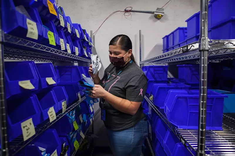 Image: An employee for Cookies dispensary in Denver reviews the store's inventory.