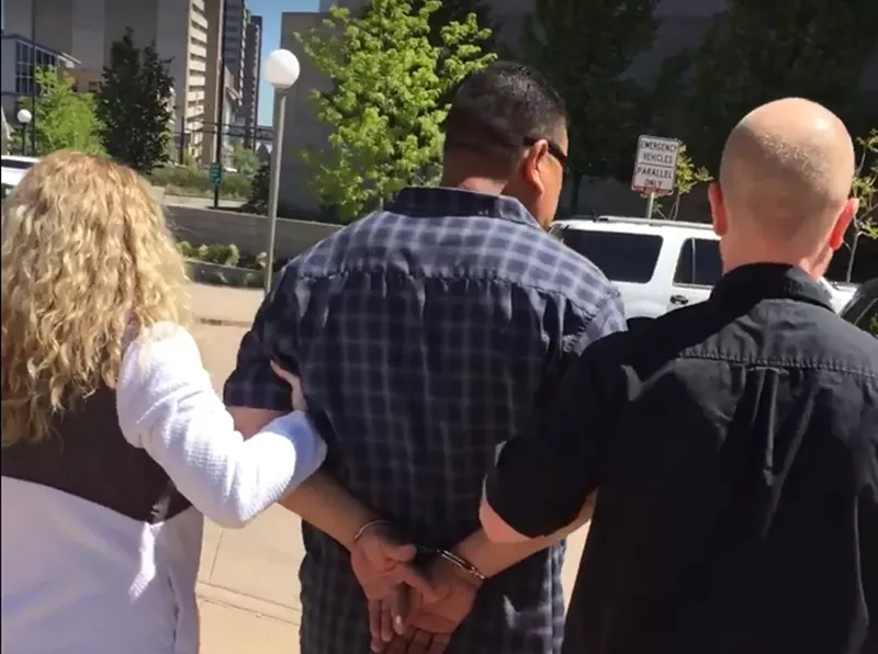 Image: A screenshot from a video of an undercover ICE arrest at a Denver courthouse.