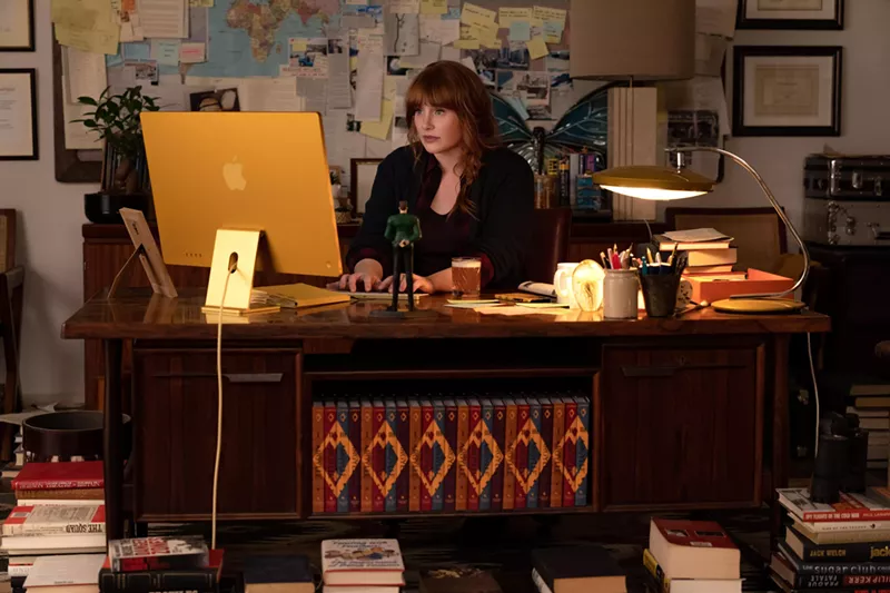 Image: woman with red hair typing at a desk