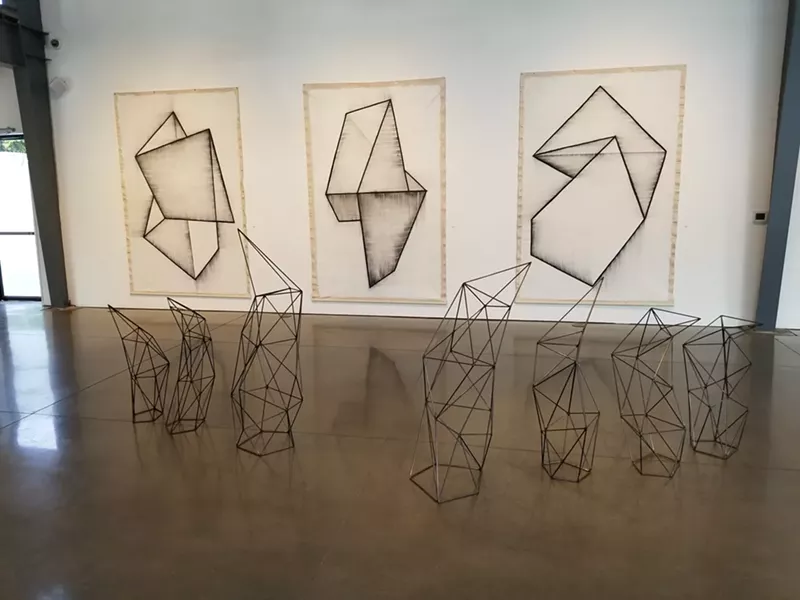 Image: Graphite and gesso paintings by Frank T. Martinez, with Jodie Roth Cooper sculptures in the foreground.