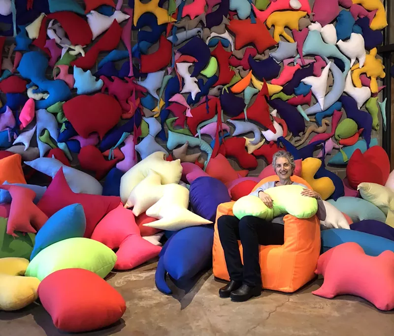 Image: RedLine founder Laura Merage sitting in her “Nausy Nauzy” installation.