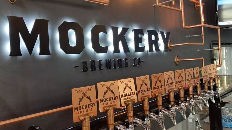 Image: wooden beer taps against a grey wall