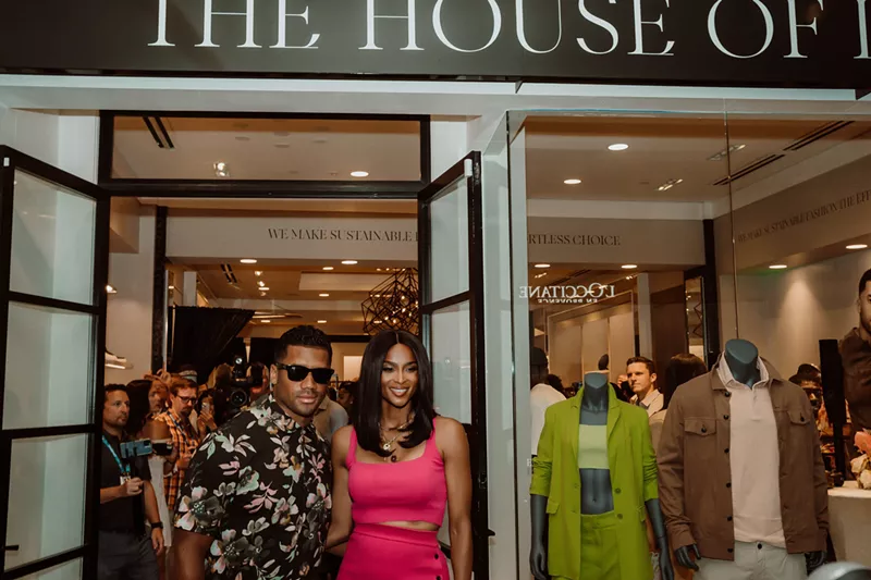 Image: russell wilson and ciara wilson pose outside their boutique.