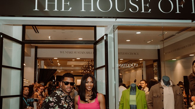 russell wilson and ciara wilson pose outside their boutique.