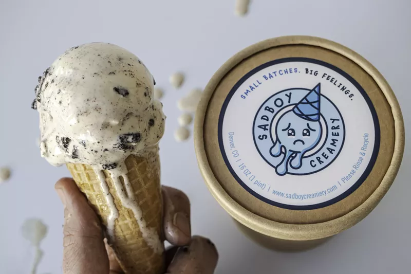 Image: a hand holding an ice cream cone next to a pint of ice cream