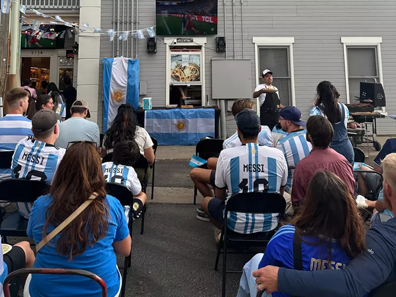 Image: people in blue and whte striped jerseys sitting in chairs outside