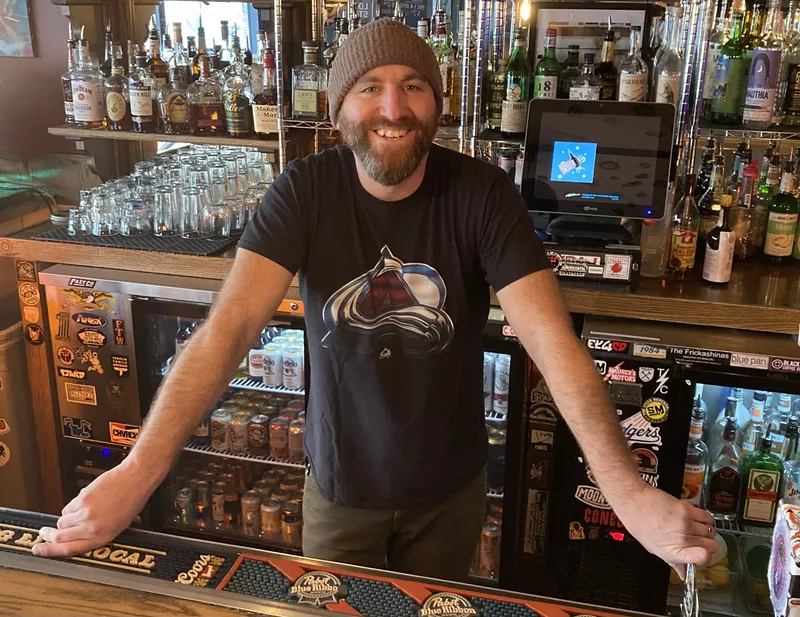 Image: Michael John standing behind a bar.