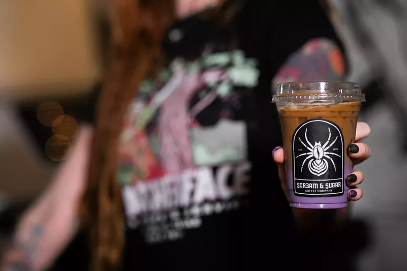 Image: person holding a purple drink in a cup