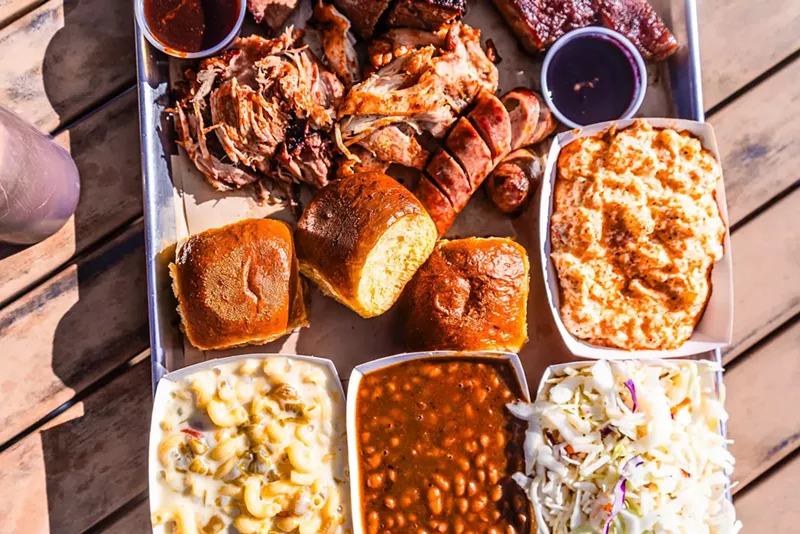 Image: a platter of barbecue meats and sides