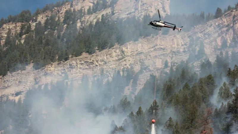Image: A helicopter dropping water on the Two Elk fire.