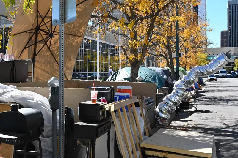 Image: A tent in front of the U.S. Post Office has a makeshift stove pipe sticking out.