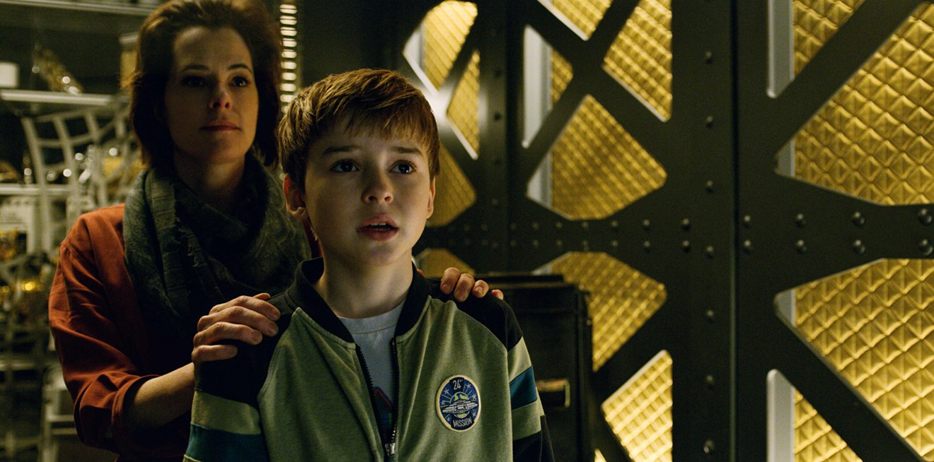 Maxwell Jenkins (right) plays Will Robinson, one of the three children in a family Lost in Space, a Netflix series in which Dr. Smith, the conniving, bitter and self-serving villain, is portrayed by Parker Posey.