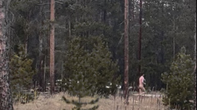naked man running away in woods.