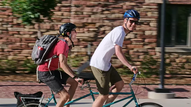 Two people riding on a tandem bicycle in Boulder