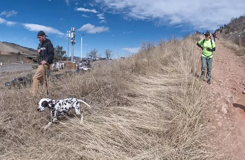 Image: A man and a dalmatian search for a missing person along a ridge in Golden, Colorado.