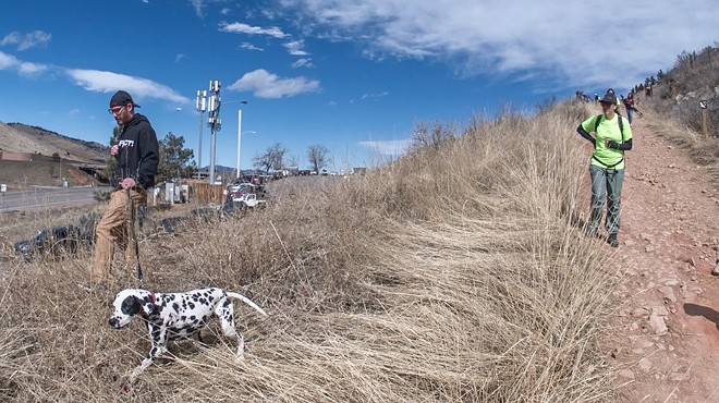 A man and a dalmatian search for a missing person along a ridge in Golden, Colorado.