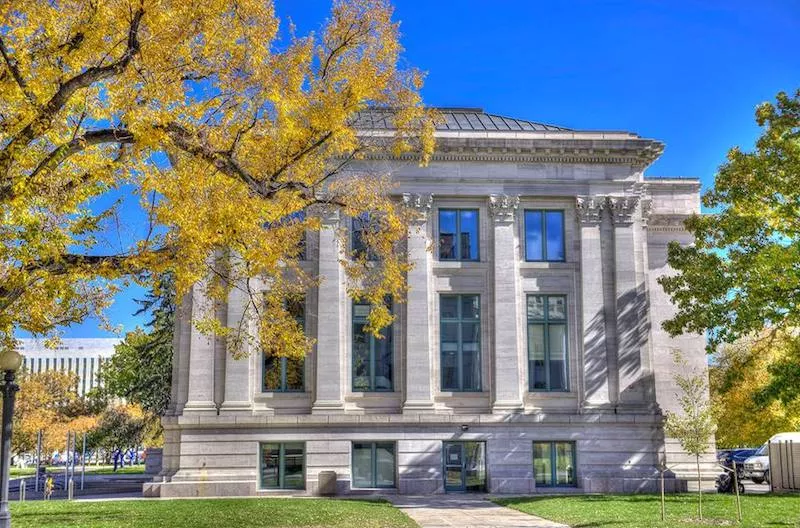 Image: A white stone building with columns and tall windows.