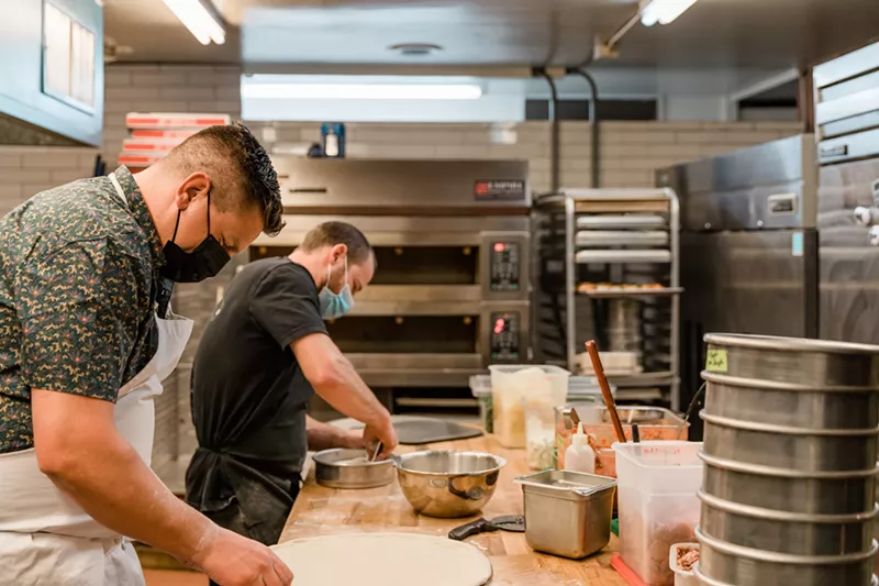 Image: Spencer White (front) and Alex Figura prep Redeemer pizzas.