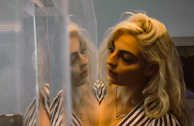 Image: YaSi in front of Kristin Hatgi Sink's "Honey, Bath."