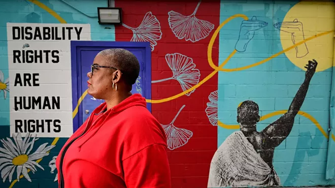 woman standing in front of an art installation