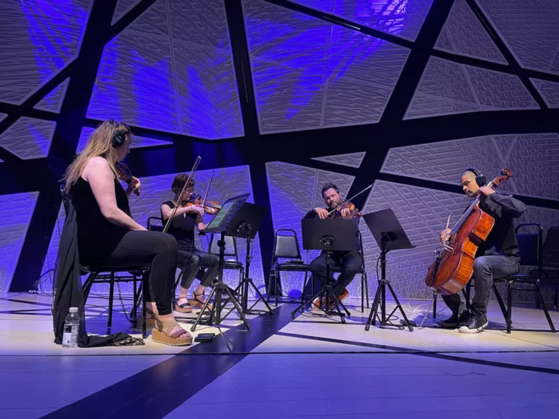 Image: a string quartet performs amid blue lighting