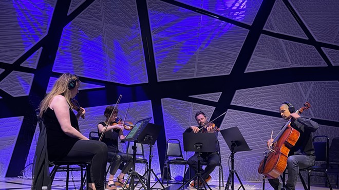 a string quartet performs amid blue lighting