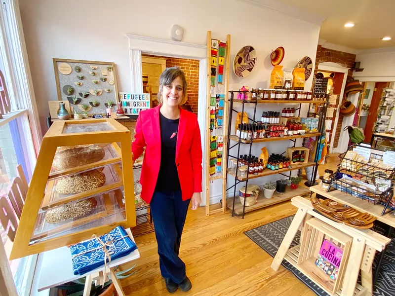 Image: a woman in a red blazer standing in a shop