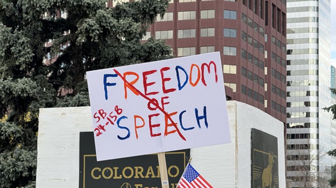Man holds freedom of speech sign during protest at Colorado State Capitol