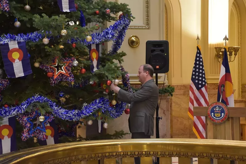Image: Ah, 2019: Governor Jared Polis hanging a Colorado chile ornament on the State Capitol tree.