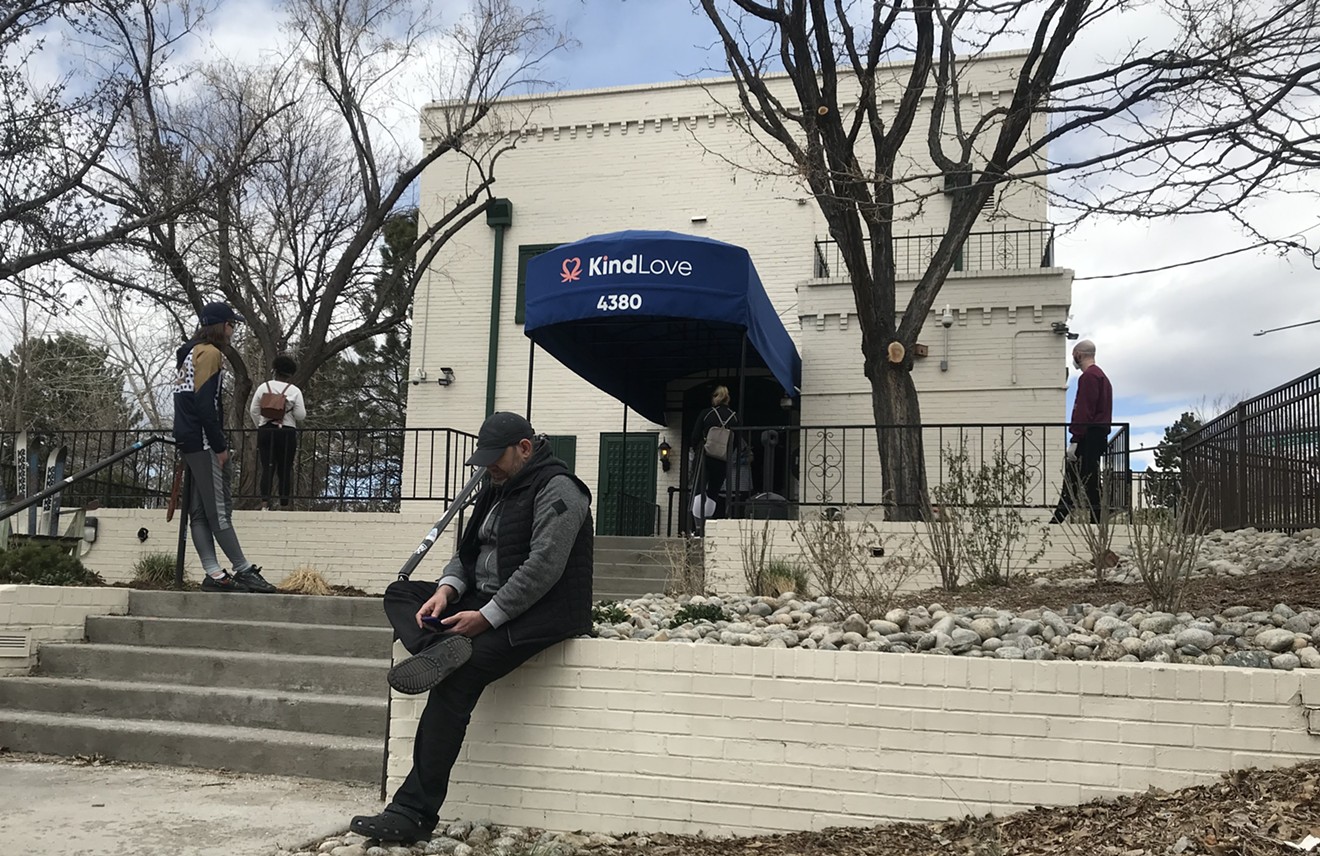 Customers wait outside of Kind Love dispensary to pick up to-go orders on Wednesday, April 15.