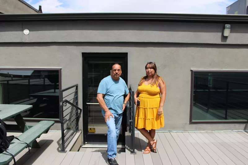 Image: man and woman smiling outside of a building