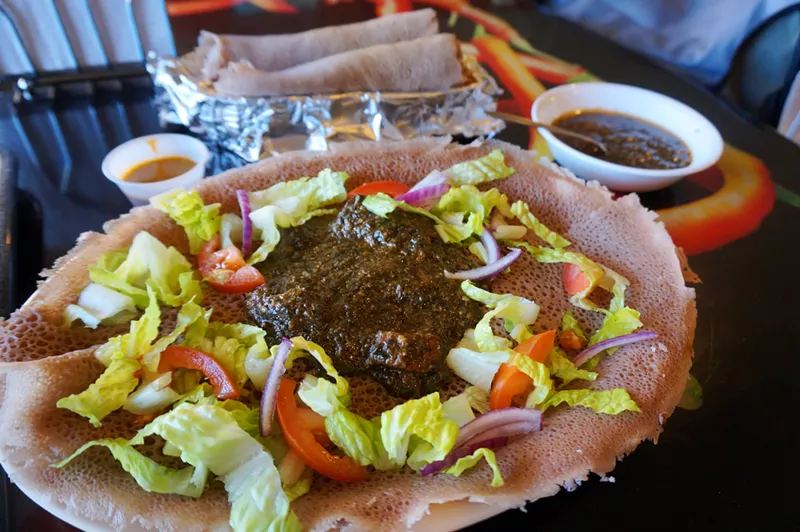 Image: Molokhia with chunks of lamb atop housemade injera bread.